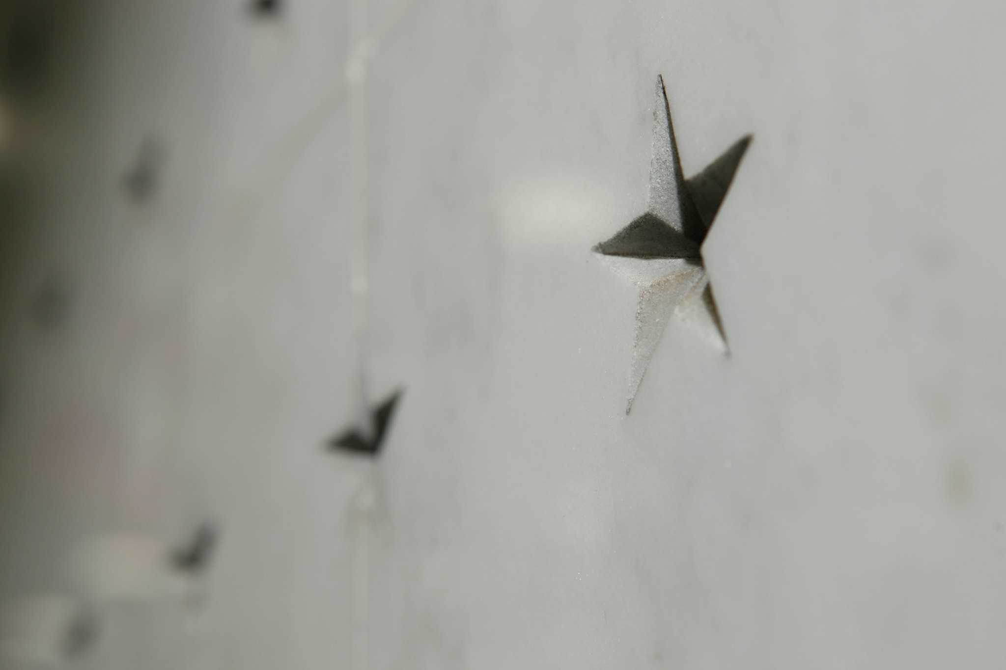 A close up of an engraved star on the memorial wall.